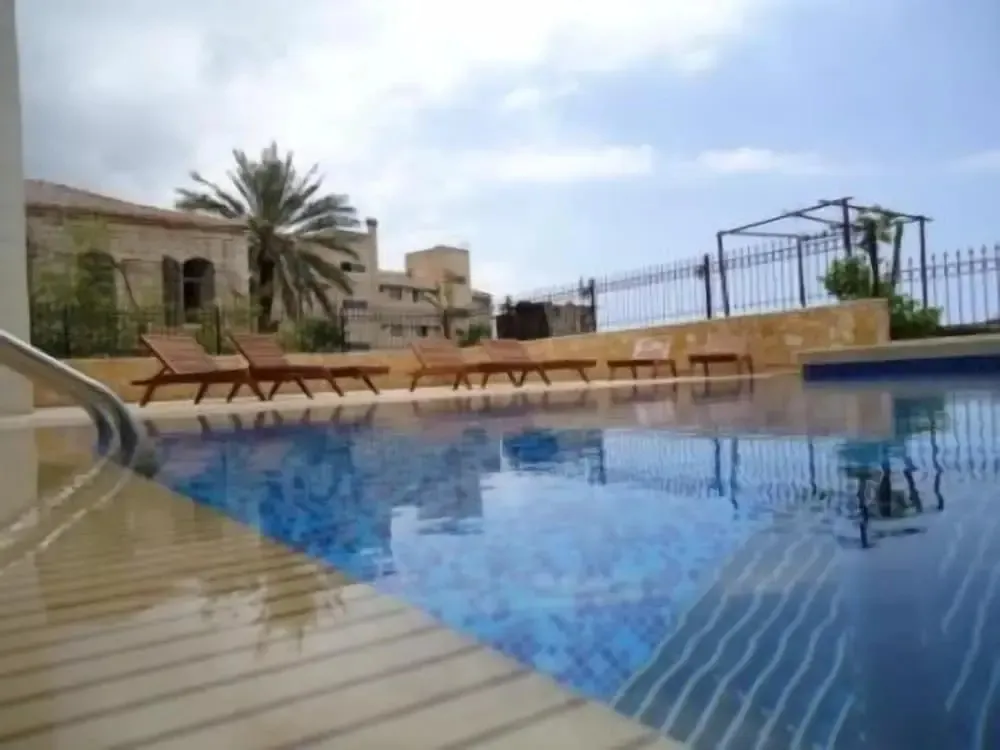 Transats alignés au bord d'une piscine ensoleillée.
