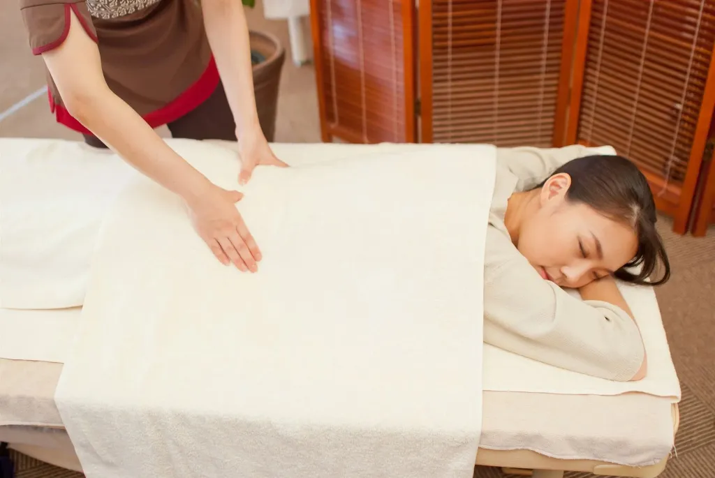 Une personne reçoit un massage allongé sur une table.