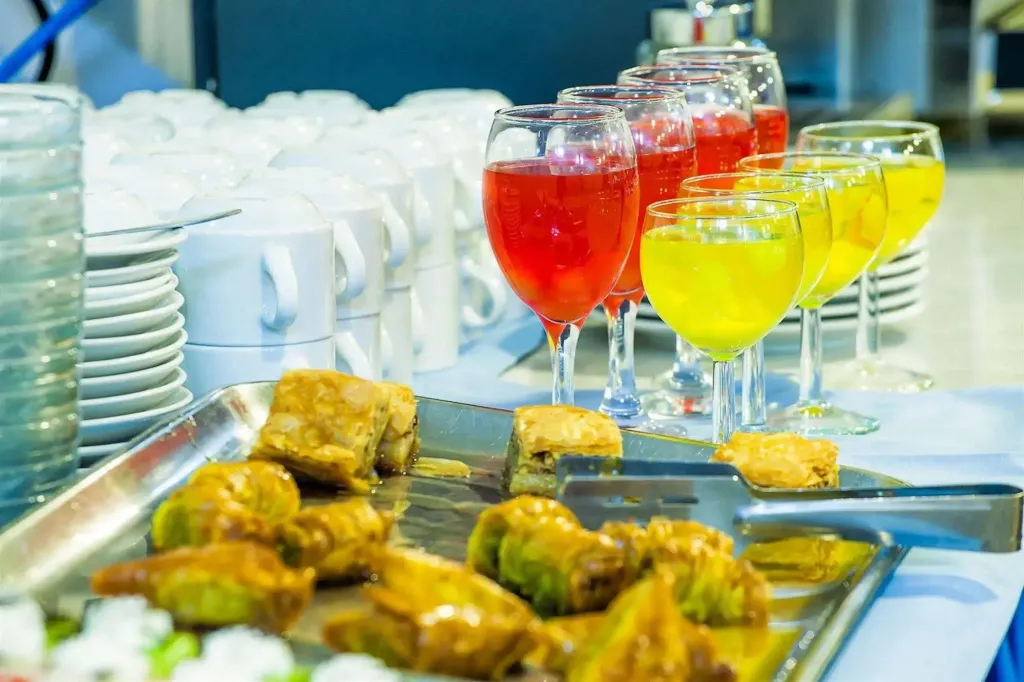Assortiment de pâtisseries et de boissons colorées présentées sur un buffet.