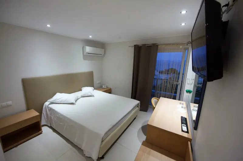 Une chambre lumineuse avec un grand lit et un bureau.