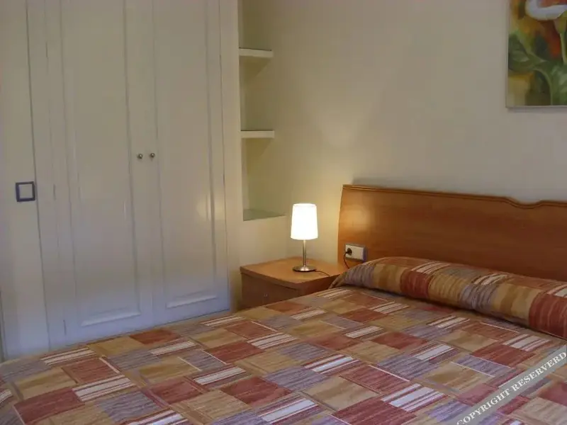 Une chambre lumineuse avec un grand lit et des meubles en bois.