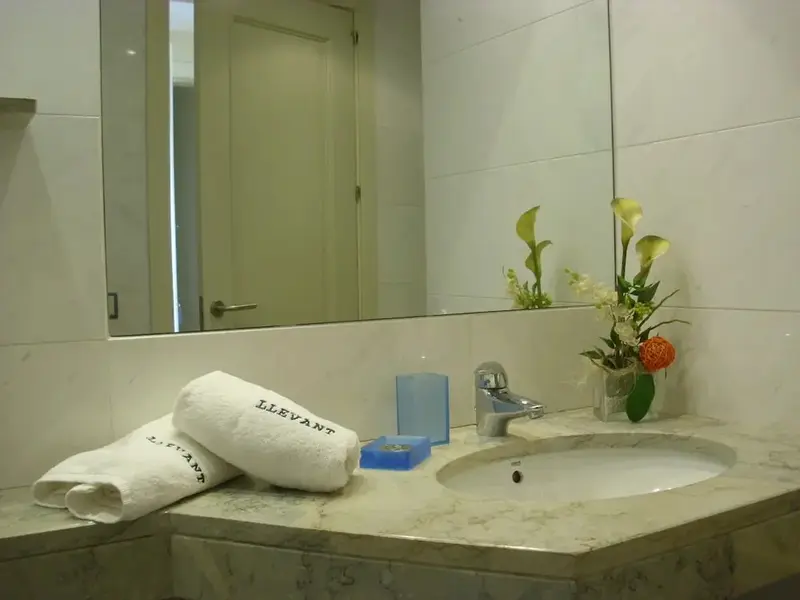 Une salle de bain lumineuse avec un lavabo et un miroir.