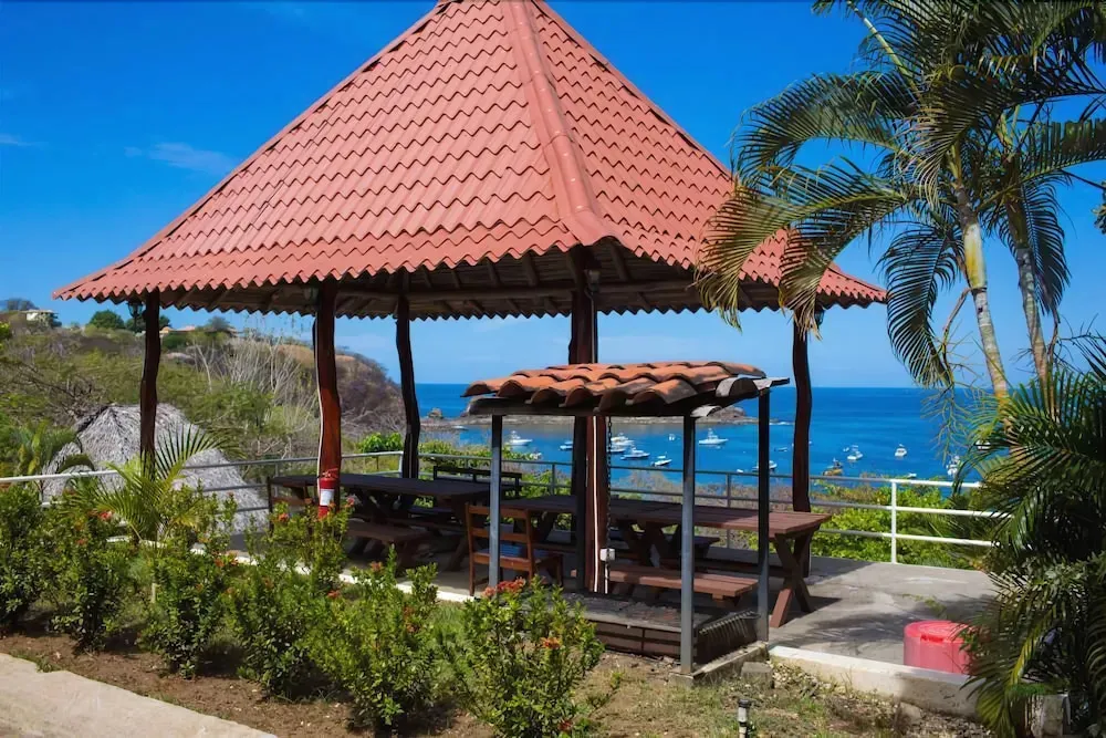 Un espace de restauration extérieur abrité offre une vue sur la mer et les bateaux.
