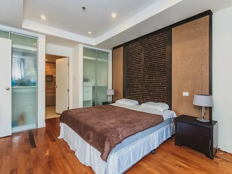 Une chambre spacieuse avec un grand lit recouvert d'une couverture marron.