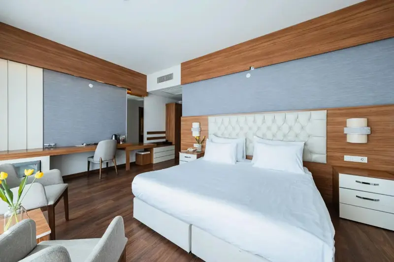 Une chambre lumineuse avec un grand lit et un espace bureau.