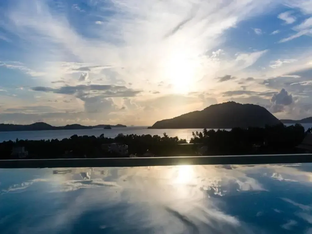 Vue sur la mer et les îles depuis une piscine à débordement au coucher du soleil.