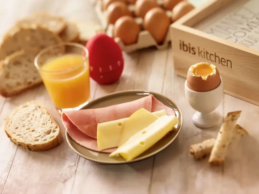 Un petit-déjeuner continental est présenté sur une table en bois clair.