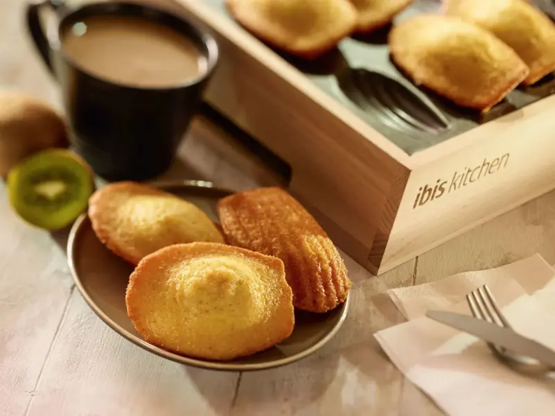 Des madeleines et une boisson chaude sont présentées sur une table.