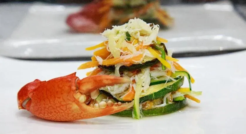 Assiette de légumes et de chair de crabe présentée avec soin.