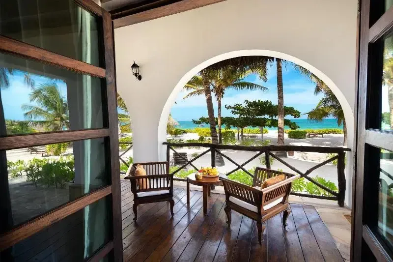 Terrasse en bois avec mobilier et vue sur la mer.