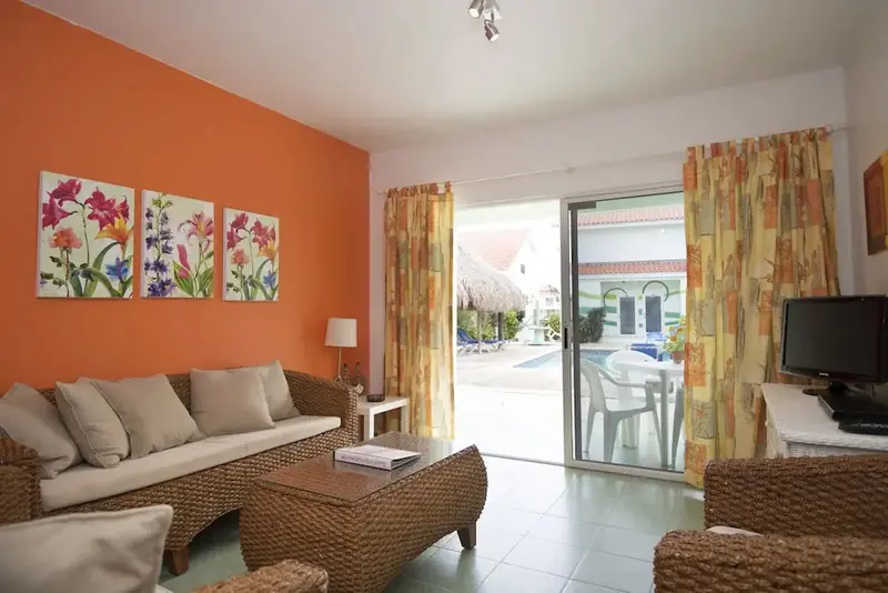 Un salon lumineux s'ouvre sur une terrasse donnant sur une piscine.