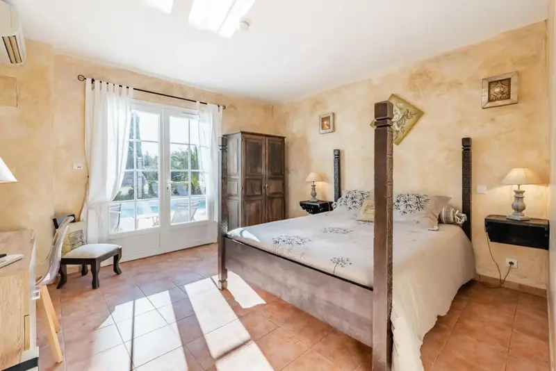 Une chambre lumineuse avec un grand lit à baldaquin et un bureau.