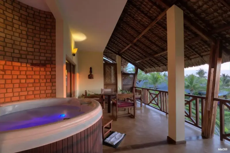 Espace de détente extérieur avec jacuzzi et mobilier de jardin.