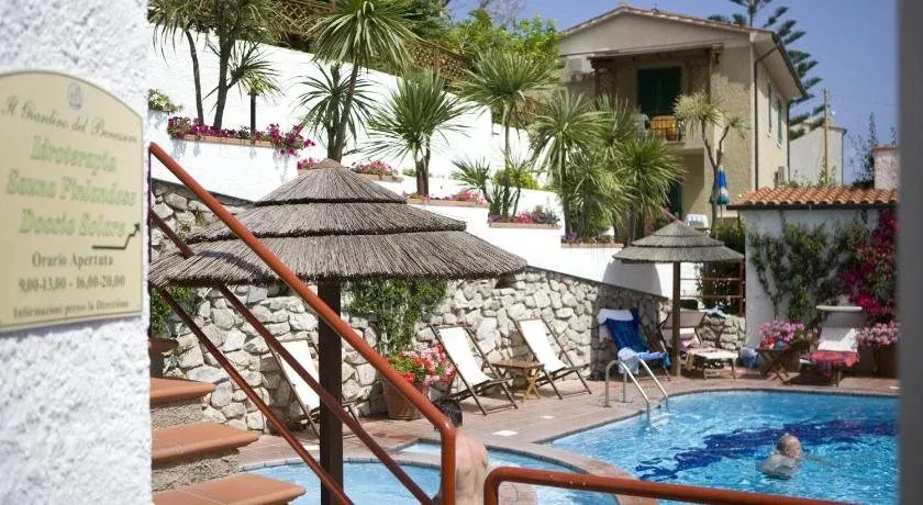 Une piscine ensoleillée avec des transats et des parasols près d'un bâtiment.