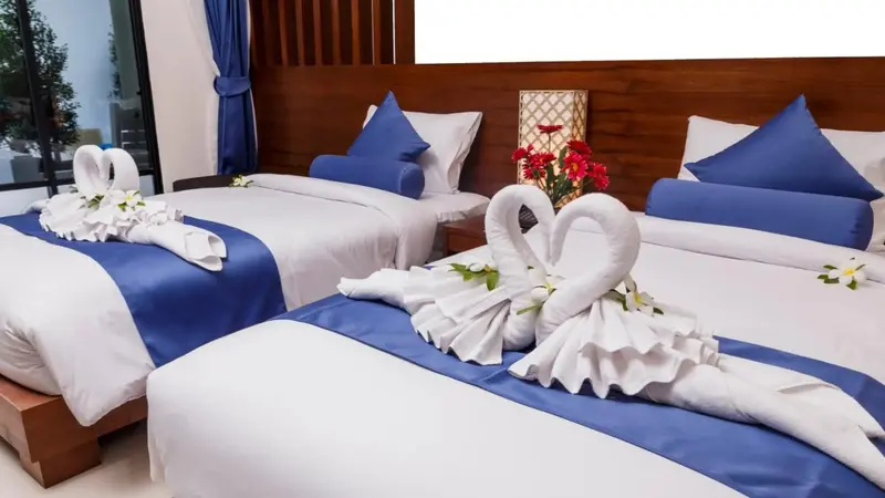 Deux lits jumeaux préparés avec des décorations en serviettes.