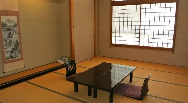 Pièce lumineuse avec table basse et assises traditionnelles sur tatamis.