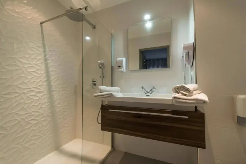 Une salle de bain moderne avec douche à l'italienne et vasque sur meuble.