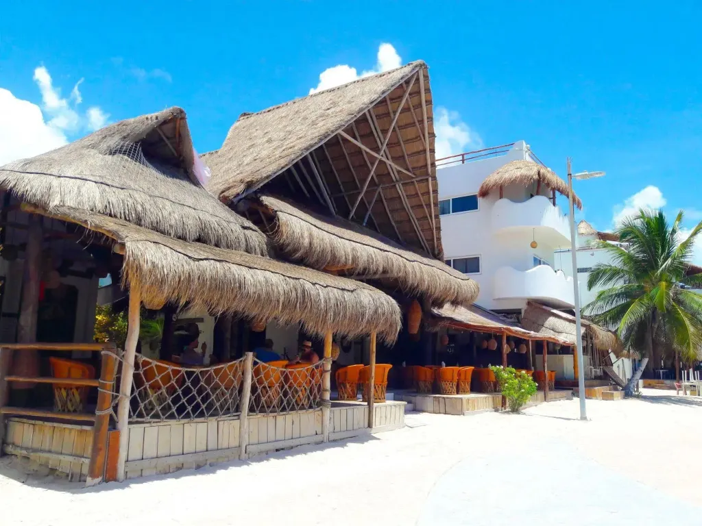 Terrasse ombragée avec mobilier en bord de plage ensoleillé.