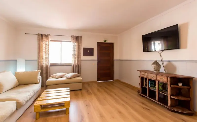 Espace de vie intérieur lumineux avec canapé et télévision.