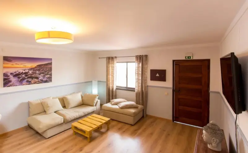 Espace de détente intérieur avec canapés et télévision.