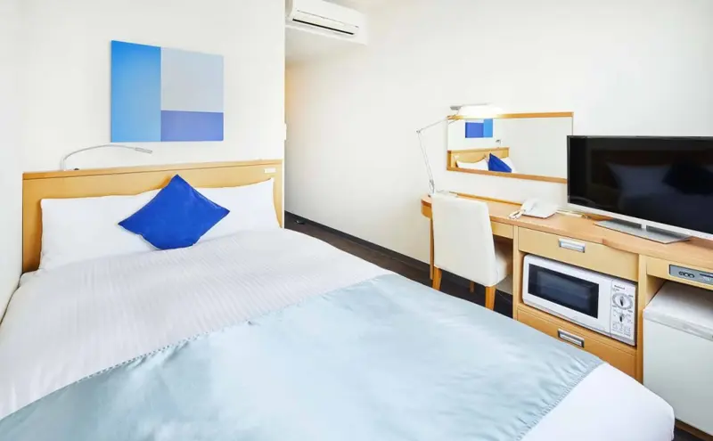 Une chambre lumineuse avec un lit simple et un bureau.