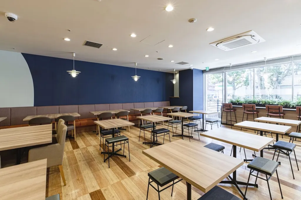 Une salle lumineuse avec des tables et des chaises en bois.
