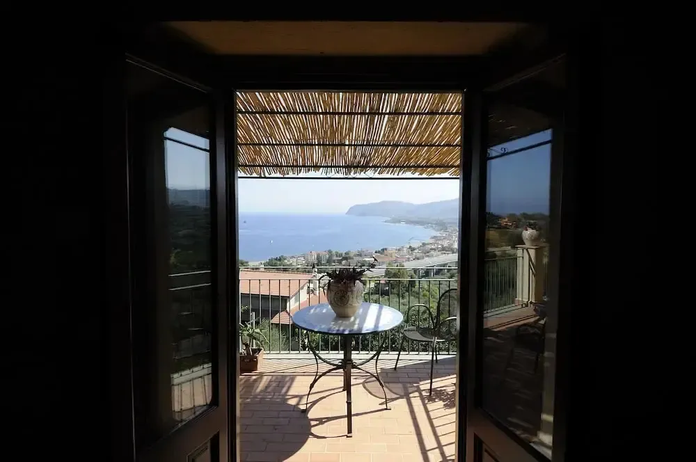 Vue sur la mer depuis une terrasse ombragée.