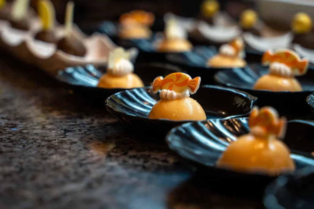 Assortiment de desserts individuels présentés sur des assiettes noires.