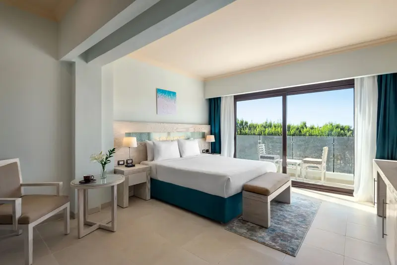 Une chambre lumineuse avec un grand lit et un accès à une terrasse.