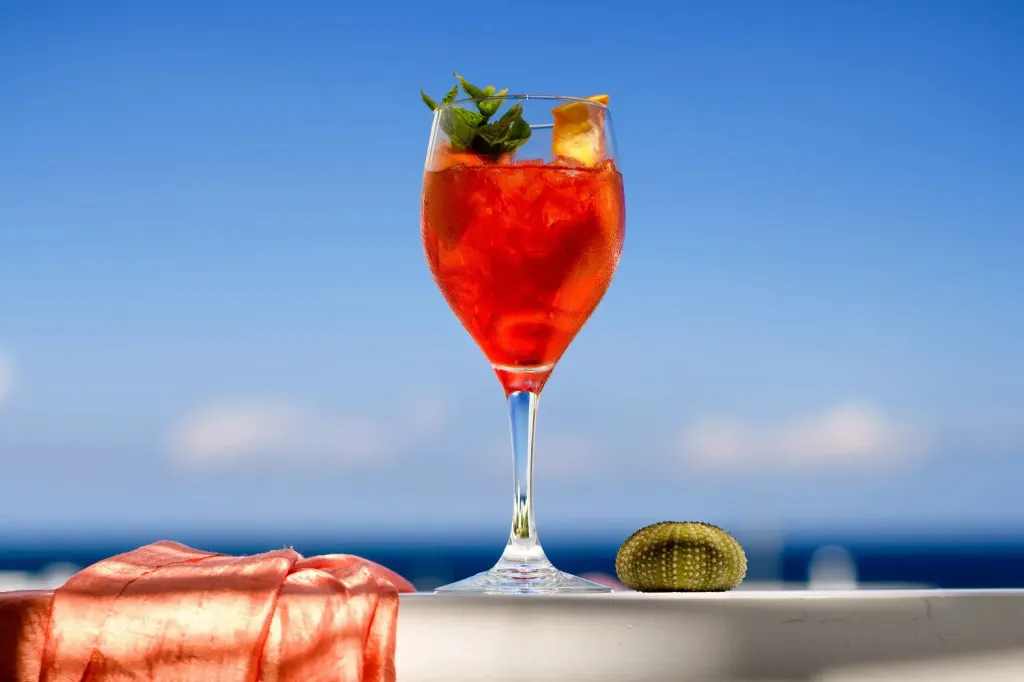 Un cocktail rafraîchissant est servi dans un verre haut avec une vue sur la mer.