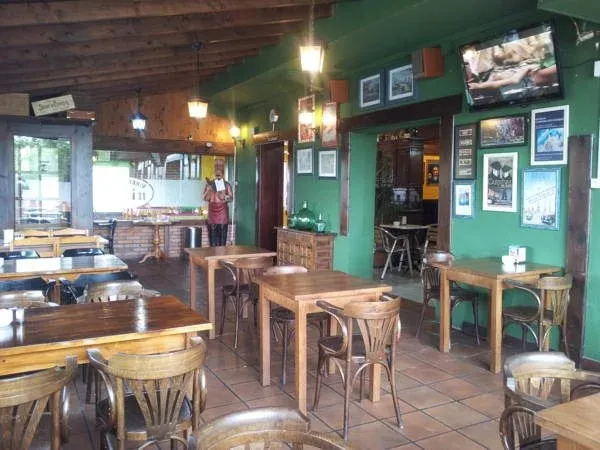 Une salle de restaurant lumineuse avec des tables en bois et des chaises.