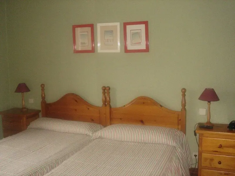 Une chambre avec deux lits simples et des tables de chevet.