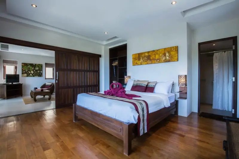 Une chambre spacieuse avec un grand lit et un accès à un espace salon.