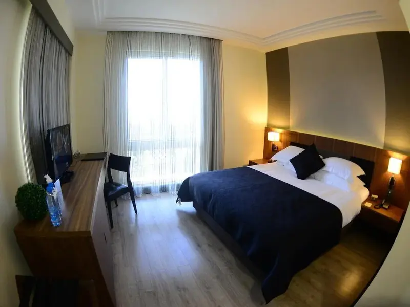 Une chambre lumineuse avec un grand lit et un bureau.