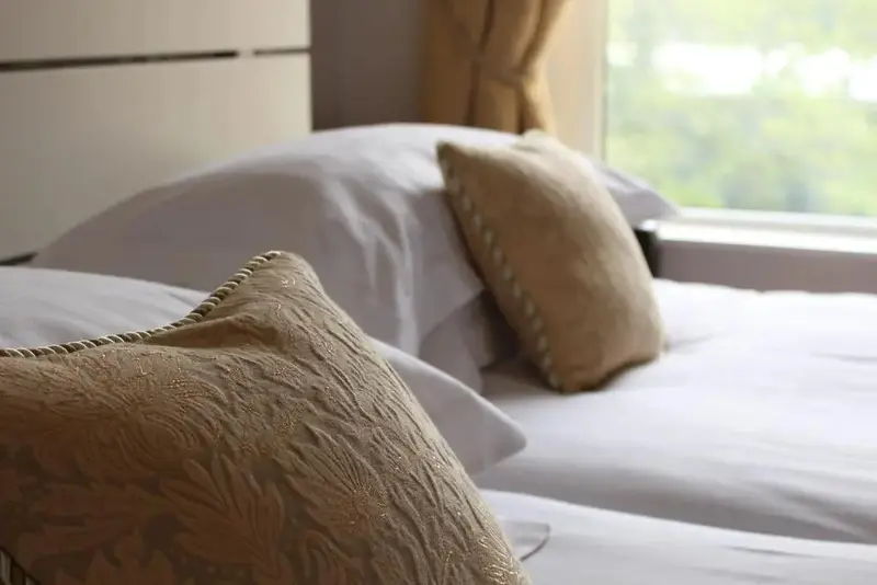 Lits préparés avec des oreillers décoratifs dans une chambre.