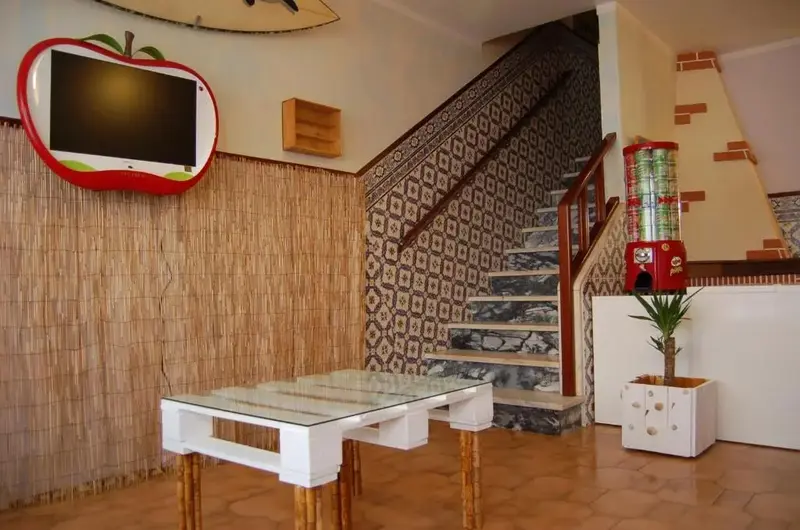 Une télévision murale est fixée au-dessus d'une table basse en bois dans un espace intérieur décoré de matériaux naturels.
