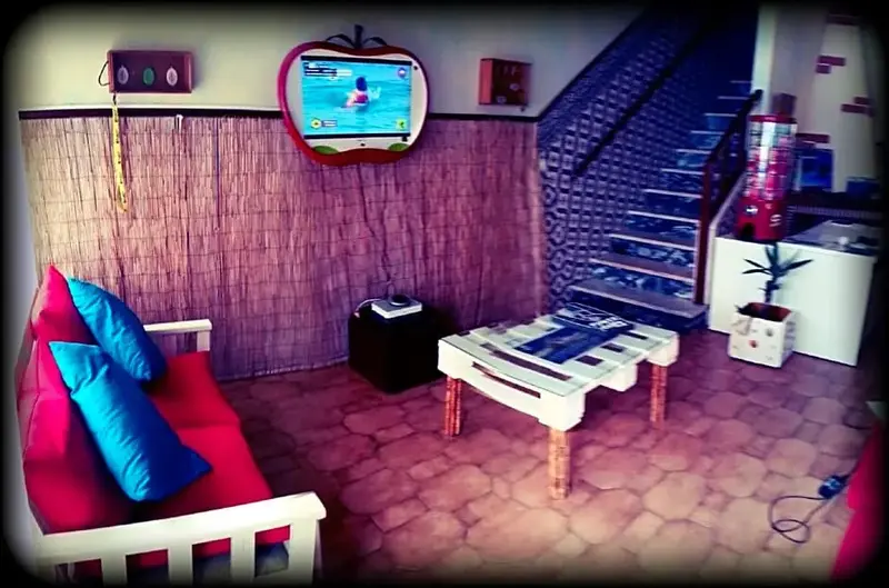 Un espace de détente intérieur avec un canapé rouge et des coussins bleus.