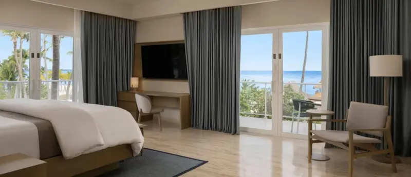 Une chambre lumineuse avec un grand lit et un accès à une terrasse.