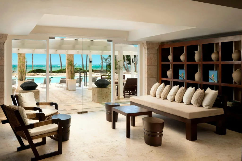 Espace de détente intérieur lumineux donnant sur une piscine et la mer.