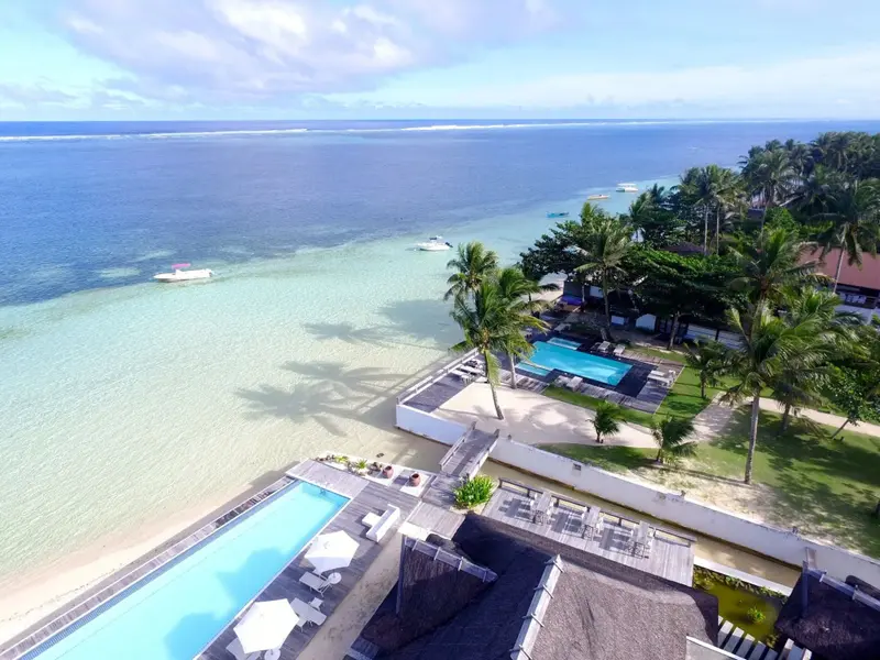 Vue aérienne d'un complexe hôtelier avec piscine et accès à la plage.