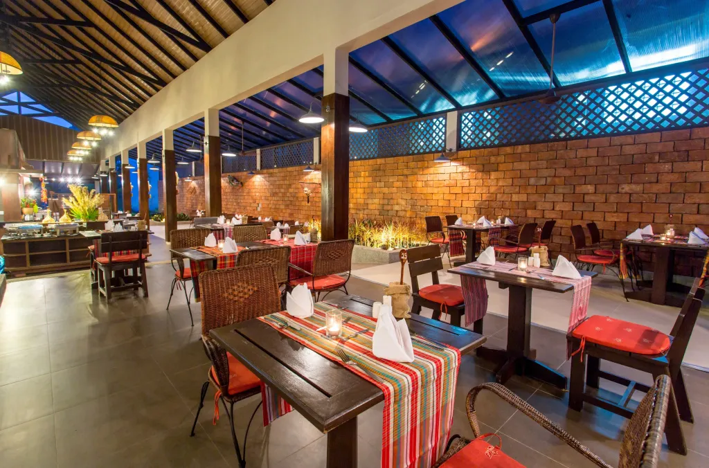Une salle de restaurant lumineuse avec des tables dressées et des clients attablés.
