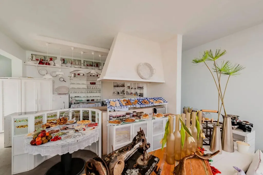 Un buffet propose des pâtisseries et des fruits frais dans une salle lumineuse.