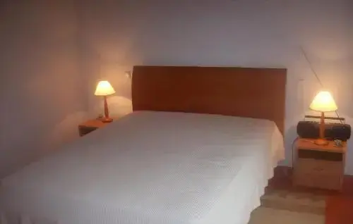 Une chambre lumineuse avec un lit recouvert d'une couverture blanche.