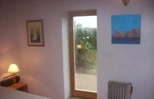 Une chambre lumineuse donne sur un jardin verdoyant.