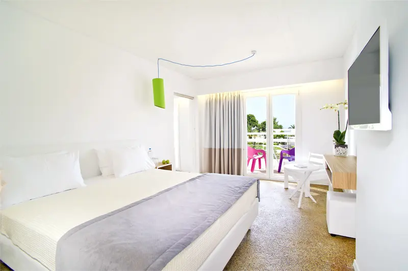 Une chambre lumineuse avec un grand lit et un accès à une terrasse.