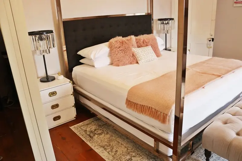 Une chambre lumineuse avec un grand lit à baldaquin et une décoration soignée.