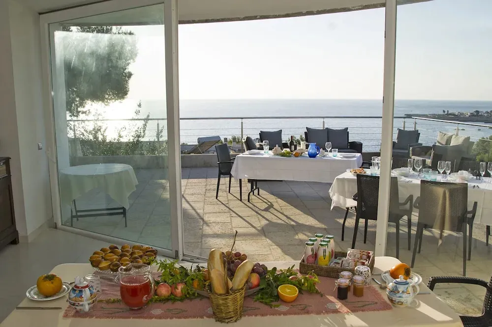 Une table est dressée avec un petit-déjeuner face à la mer.