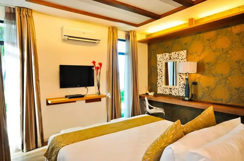 Une chambre lumineuse avec un grand lit recouvert d'une courtepointe jaune et or.