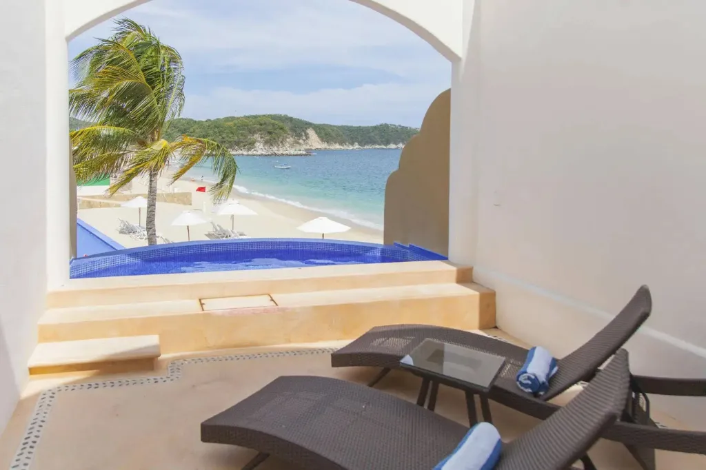 Deux chaises longues invitent à la détente face à une vue sur la mer et la plage.