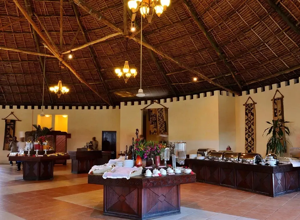 Une salle lumineuse propose un buffet garni de plats variés et de boissons.